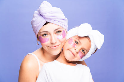 Image of female and young girl wearing under-eye masks. Both wearing head towels. 